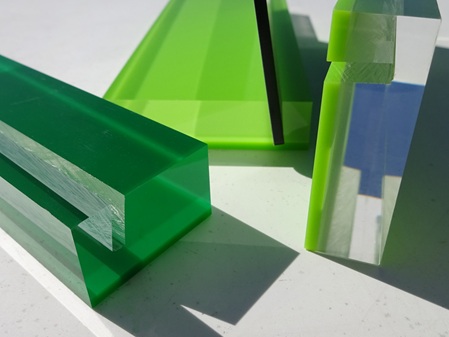 Mehrere Acrylglashalter in Sandwichmaterial (farblos und verschiedene Grüntöne) für Menükarten.