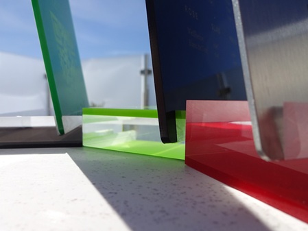Mehrere Acrylglashalter in Sandwichmaterial (farblos und verschiedene Farbtöne) für Menükarten.